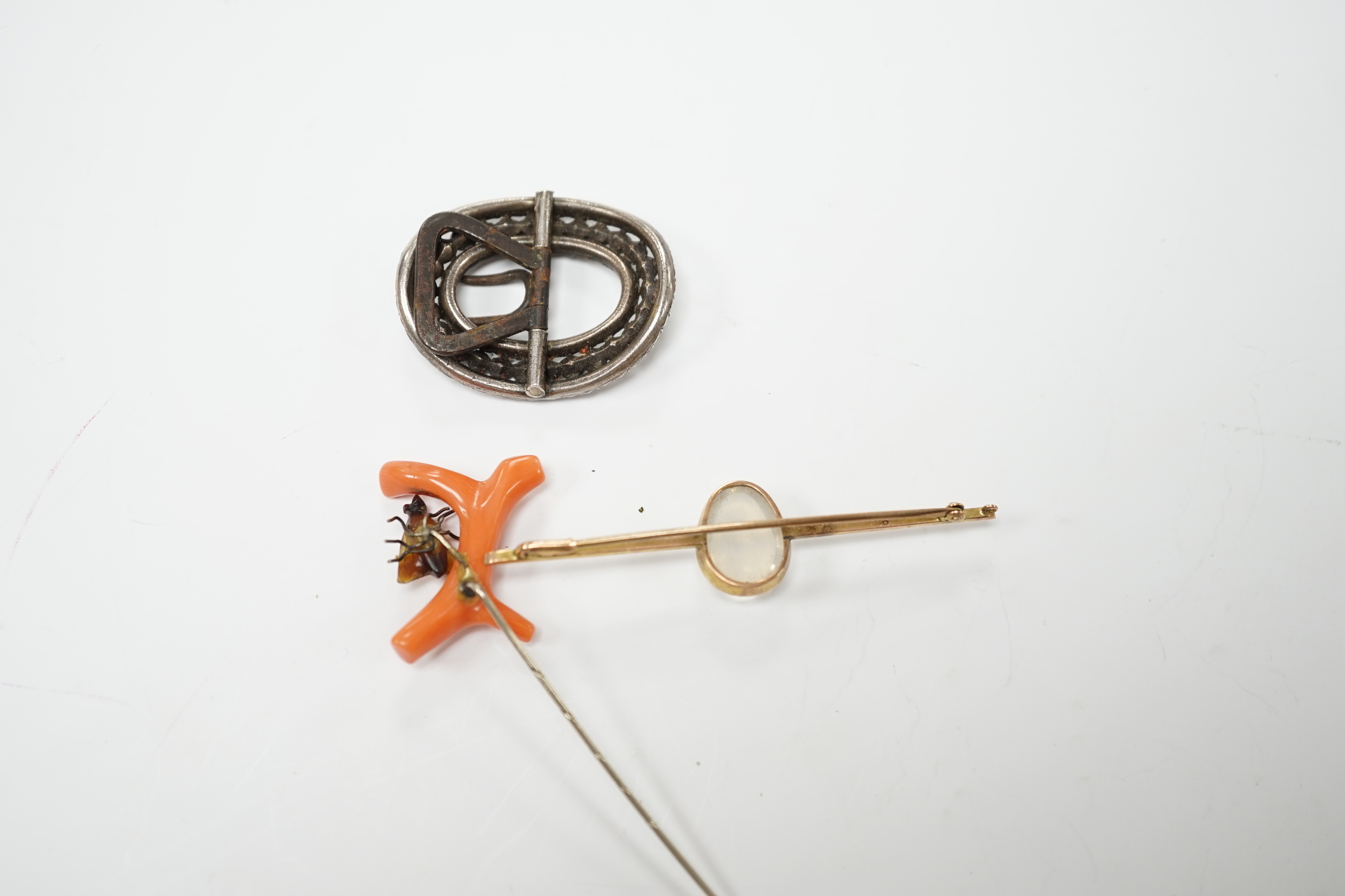 A 9ct and cabochon moonstone set bar brooch, 63mm, a coral and horn set bug stick pin and a paste set buckle.